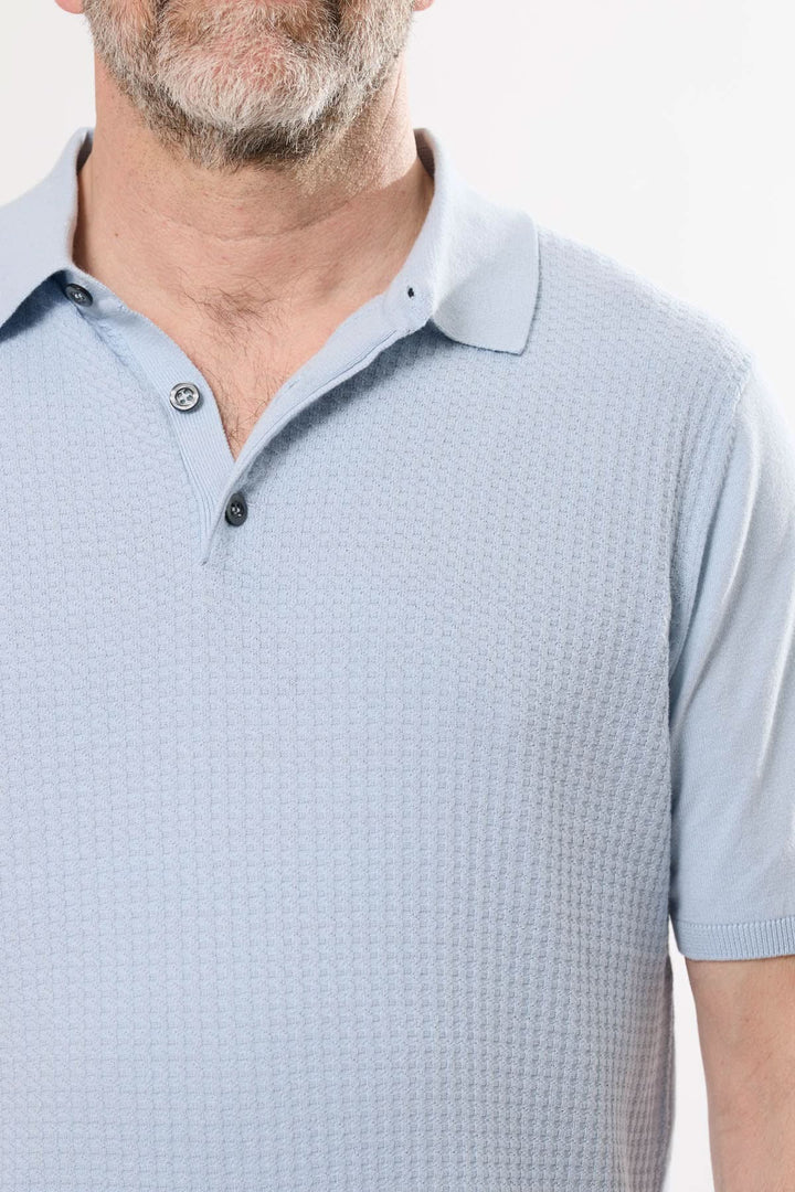 Polo rétro bleu en maille texturée, col classique et manches courtes pour un style élégant.