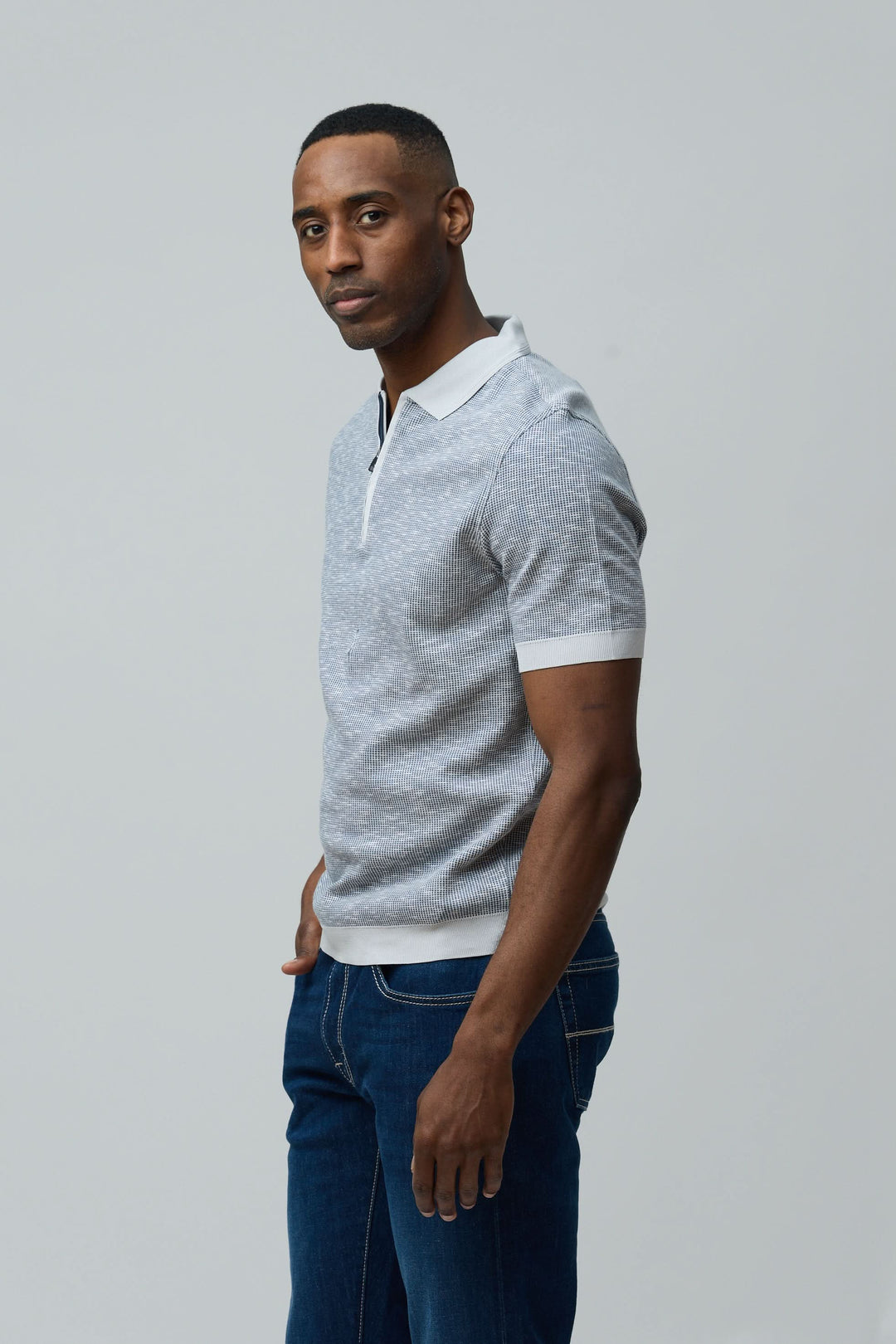 Homme portant un Polo texturé à fermeture zippée en coton peigné, coupe régulière, manches courtes, couleur grise, style décontracté.
