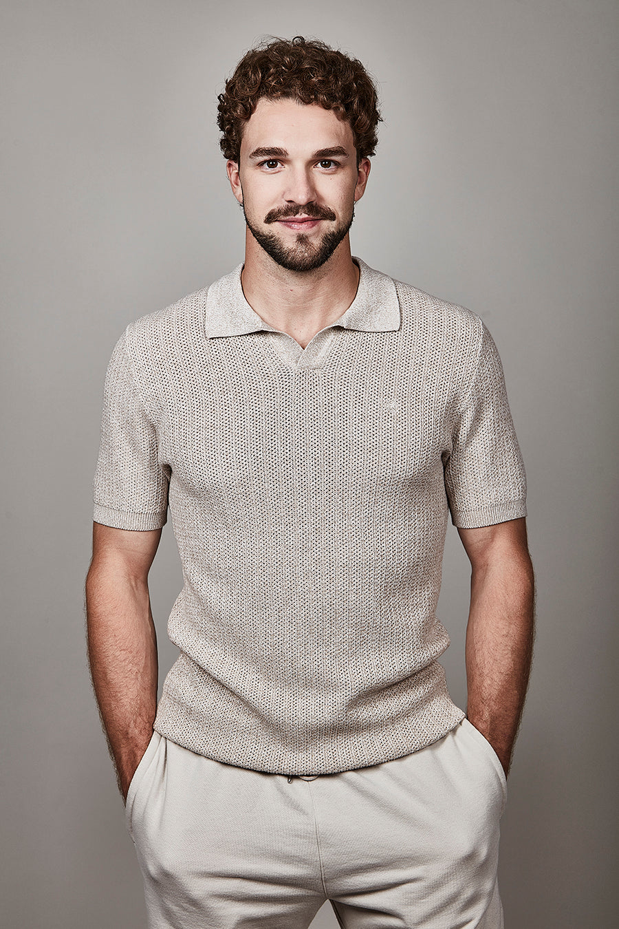 Homme portant un polo texturé à manches courtes avec maille élégante et contemporaine, idéal pour un style soigné au quotidien.
