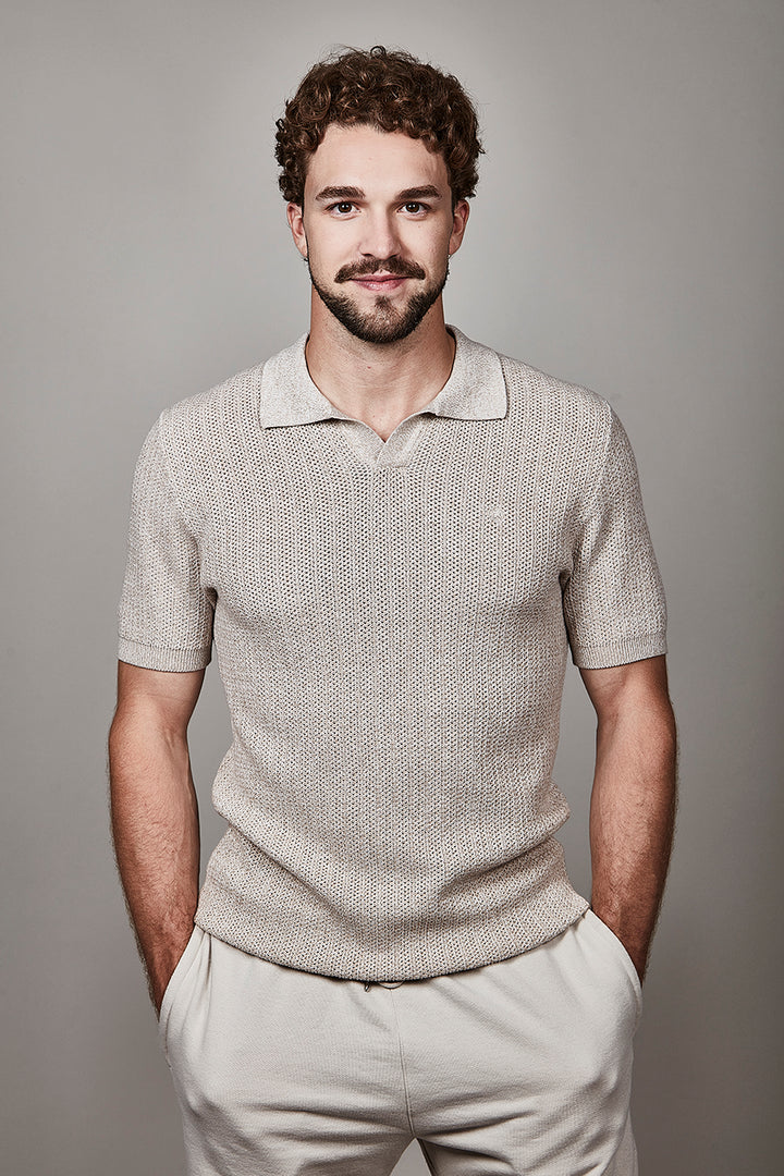 Homme portant un polo texturé à manches courtes avec maille élégante et contemporaine, idéal pour un style soigné au quotidien.