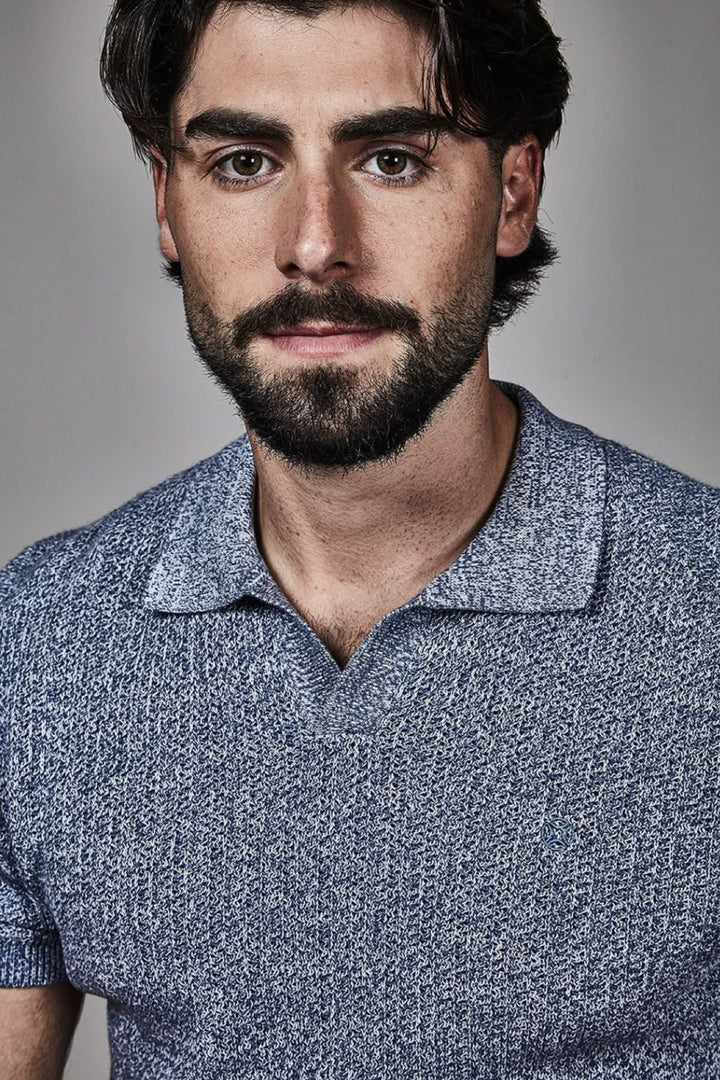 Homme portant un polo texturé à manches courtes de couleur bleu avec une maille élégante et contemporaine.
