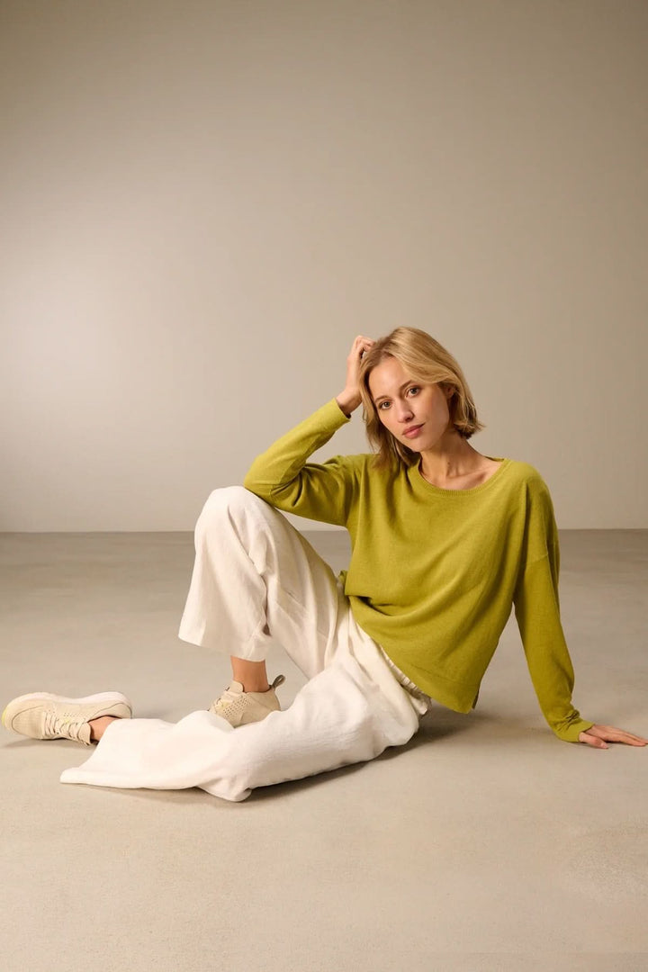 Pull léger manches longues élégant en maille douce porté avec un pantalon blanc, style décontracté pour toutes les saisons.