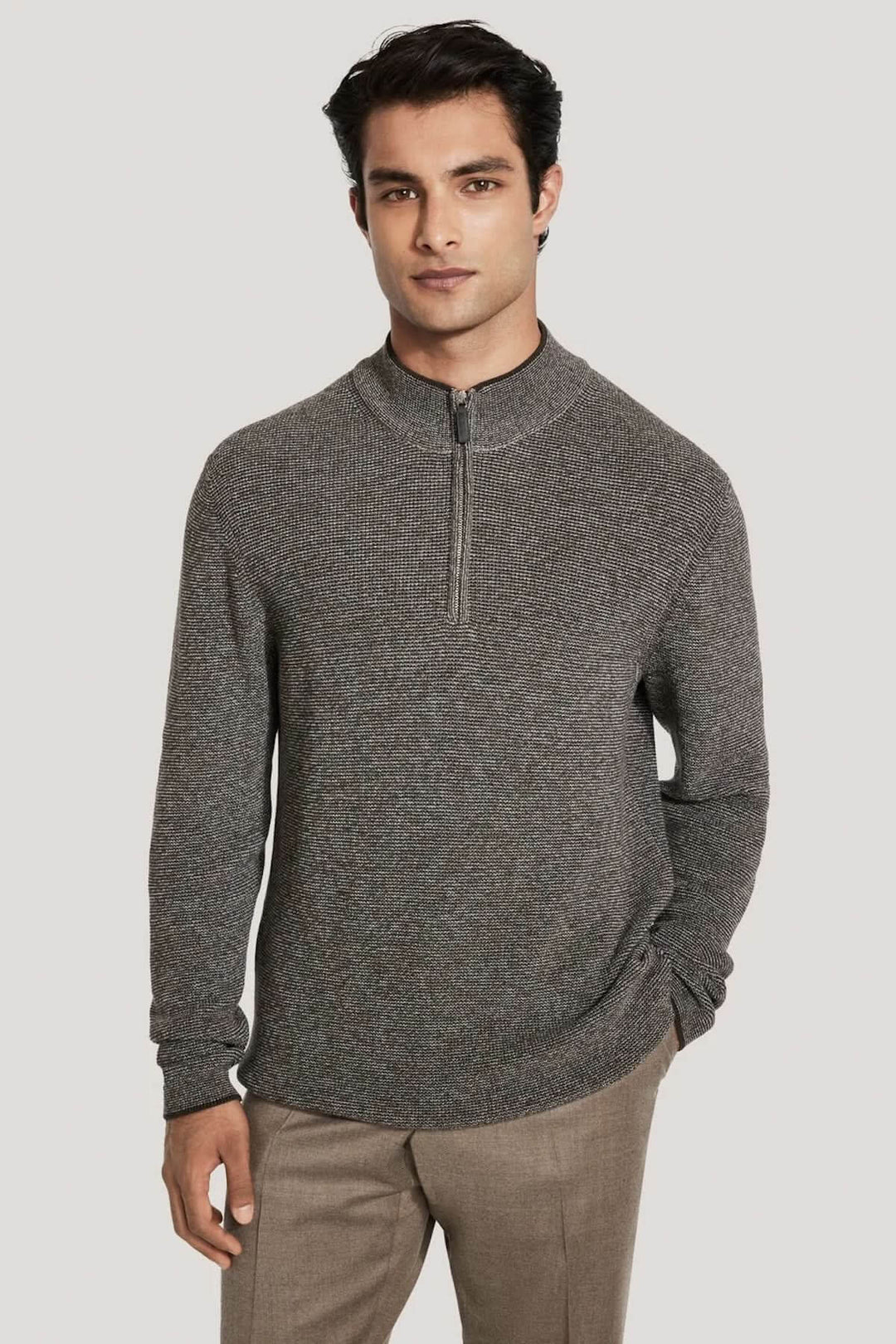 Pull quart de zip en coton texturé porté par un homme, montrant son col montant et sa fermeture éclair, idéal pour la mi-saison.