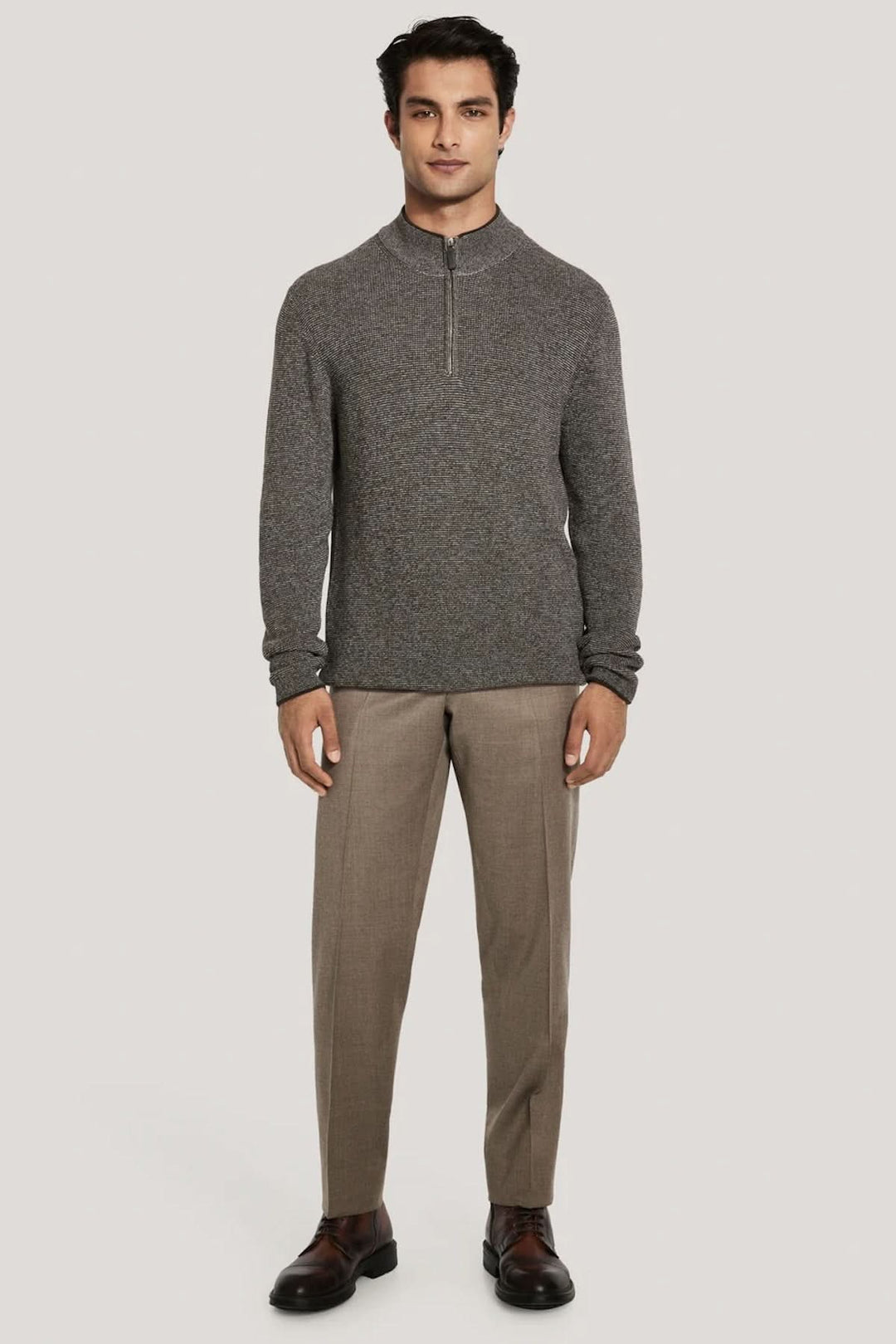 Homme portant un pull quart de zip en coton texturé avec col montant, design moderne et sophistiqué idéal pour mi-saison.
