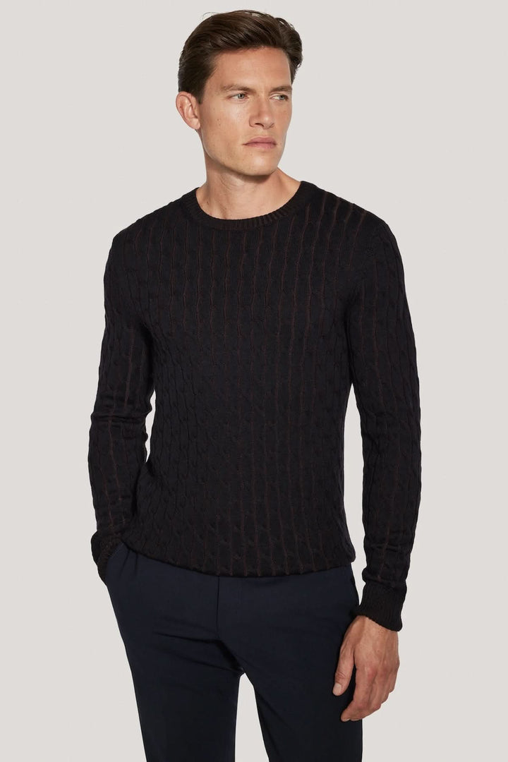 Homme portant un Pull ras du cou torsadé en laine mérinos vanisée, effet tricot vanisé, coupe élégante et moderne.