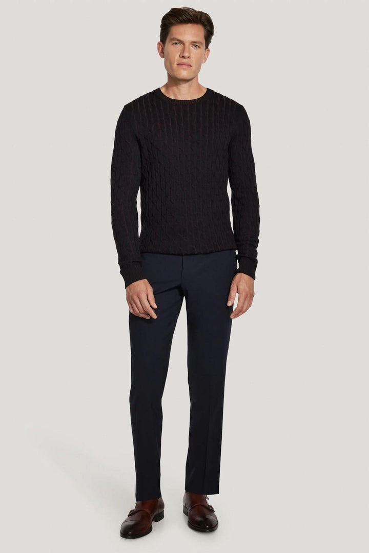 Homme portant un pull ras du cou torsadé en laine mérinos vanisée, tricot vanisé moderne avec coupe élégante, style polyvalent.