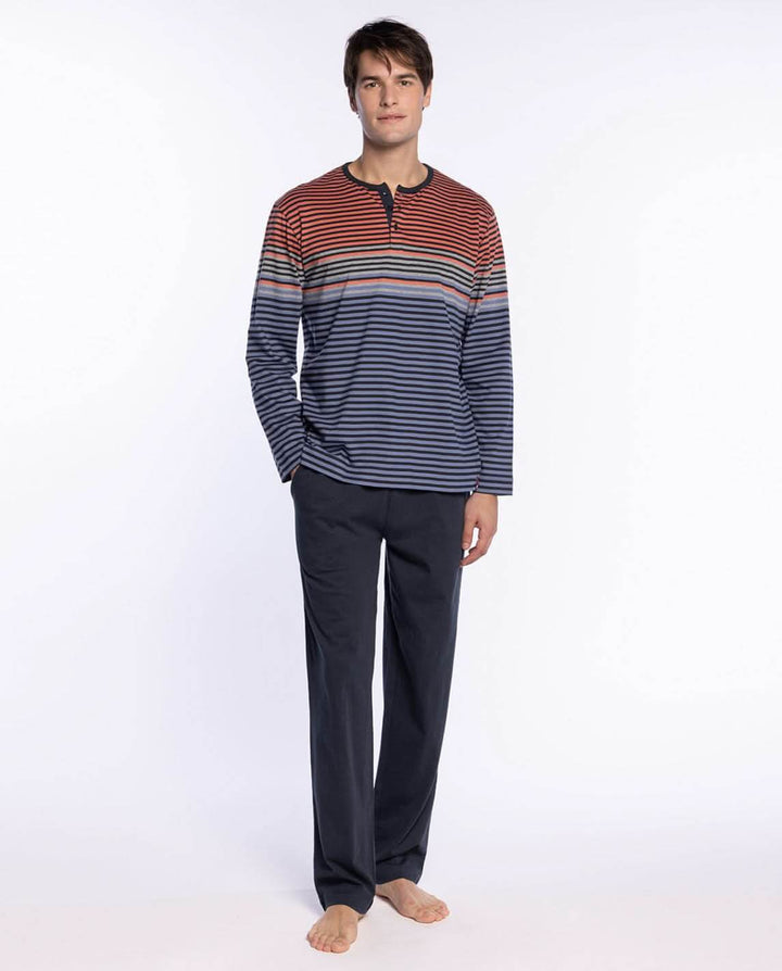 Homme portant un Pyjama Long en Coton à Rayures Sophistiqué avec haut à rayures multicolores et pantalon uni sombre.