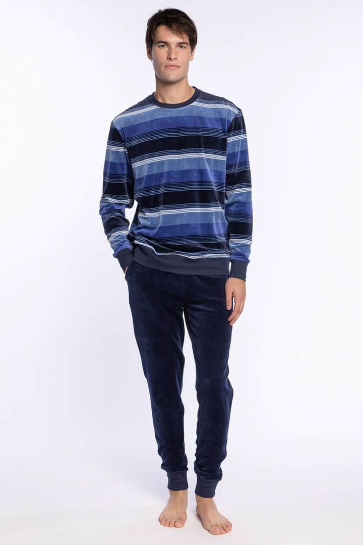 Homme portant un Pyjama Long en Velours de Coton à Rayures bleu avec manches longues, idéal pour les nuits d’hiver.