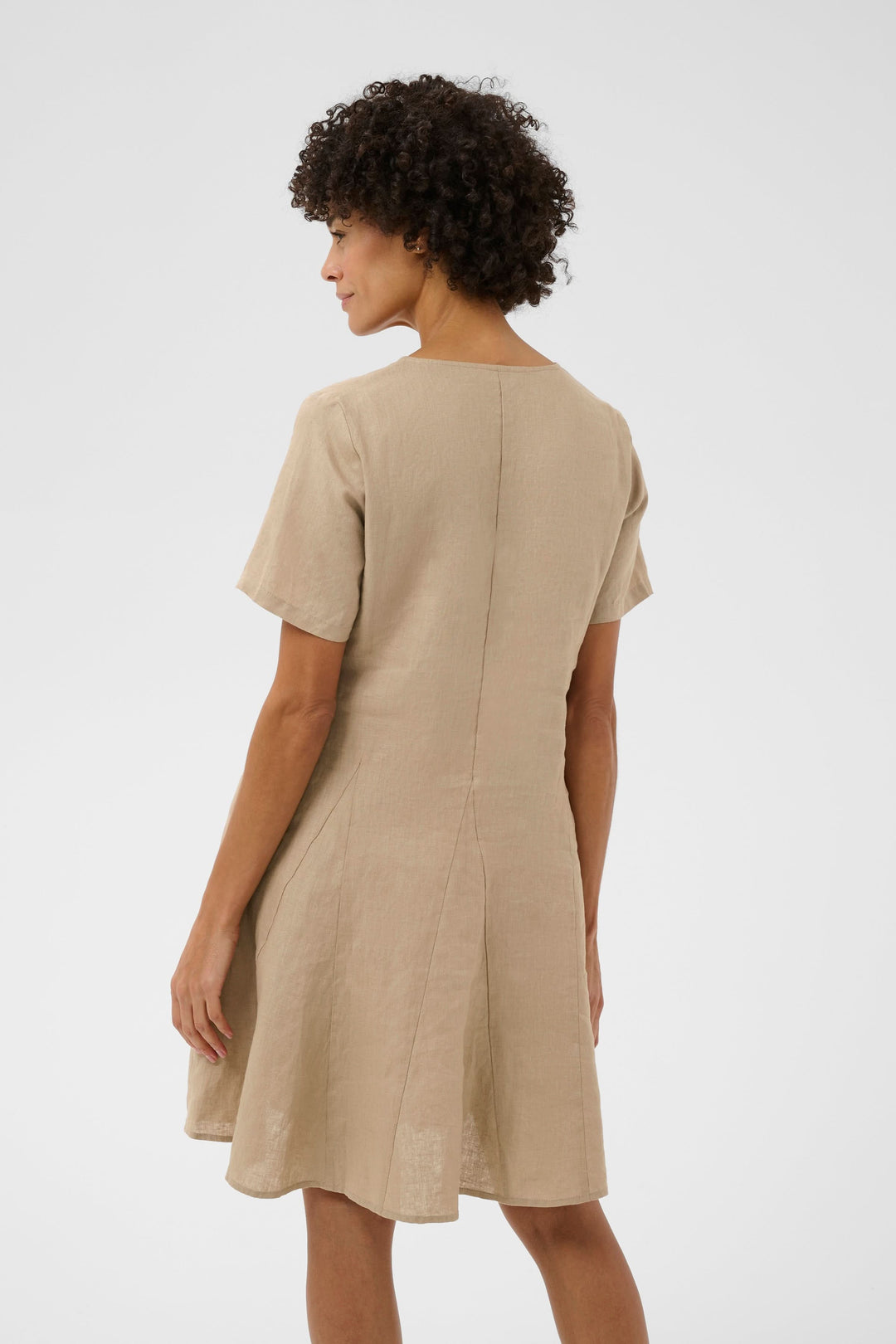 Robe Aminasa en beige avec coupe fluide, manches courtes et encolure en V, idéale pour une apparence naturelle et élégante.