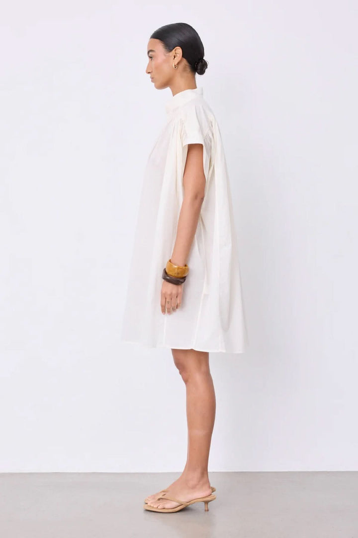 Robe Fani courte fluide col ouvert, style minimaliste avec manches courtes et encolure en V, allure épurée et élégante.