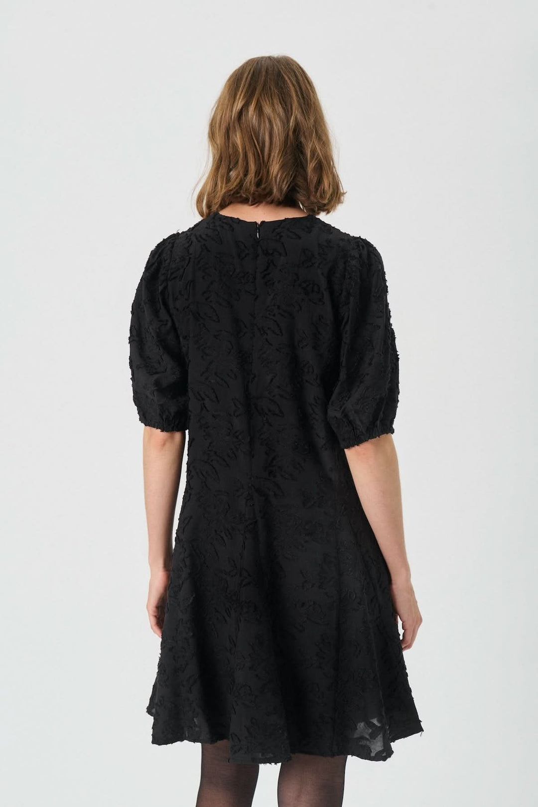 Vue arrière de la Robe Vilhelmina en dentelle à manches bouffantes, noir, élégante et féminine, avec texture florale ton sur ton.