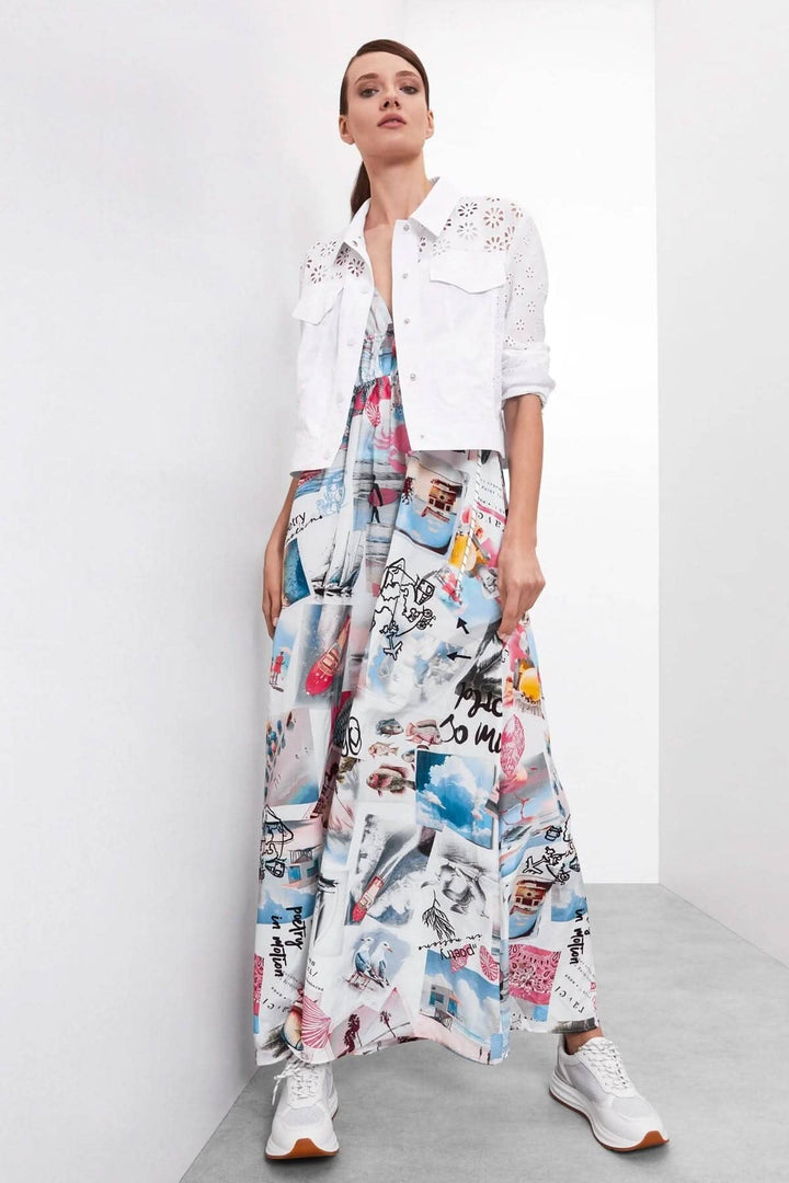 Femme portant une robe à bretelles imprimée et une veste blanche, look décontracté avec baskets gris.
