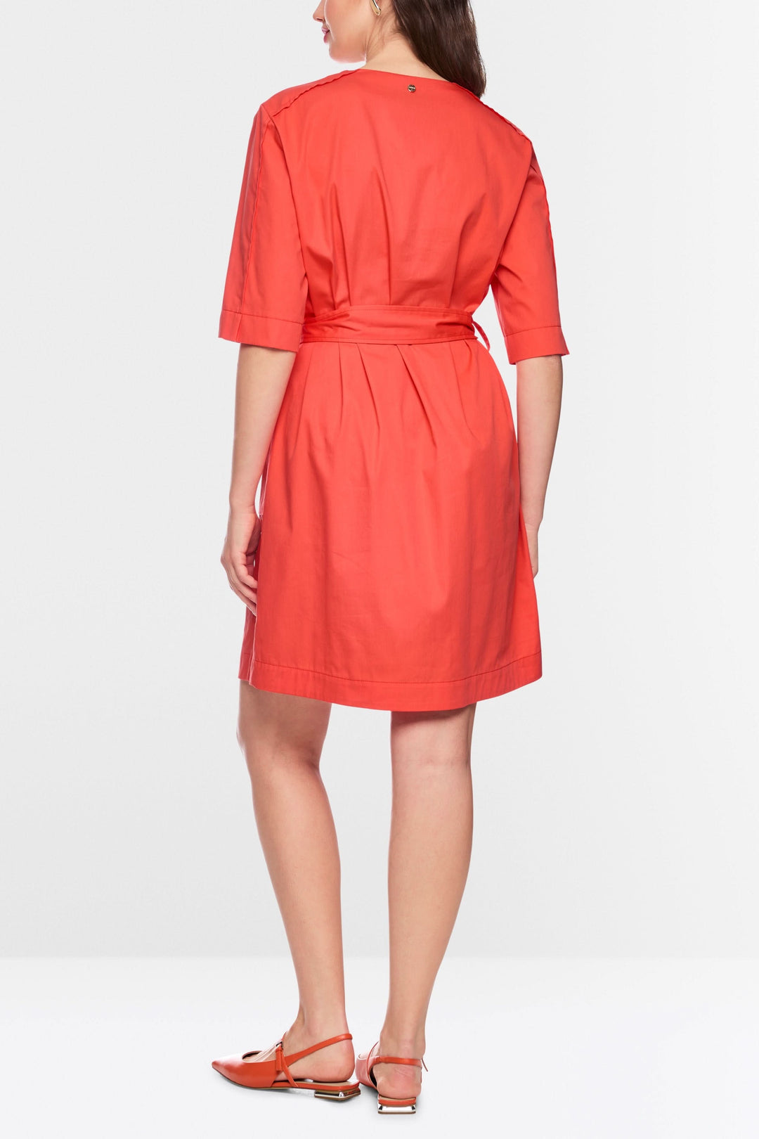 Femme portant une robe ceinturée à manches courtes vue de dos, design moderne et épuré, idéale pour toute occasion, couleur vive.