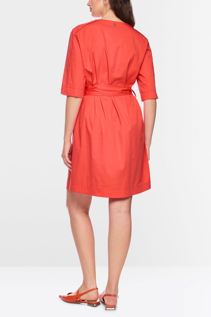 Femme portant une robe ceinturée à manches courtes vue de dos, design moderne et épuré, idéale pour toute occasion, couleur vive.