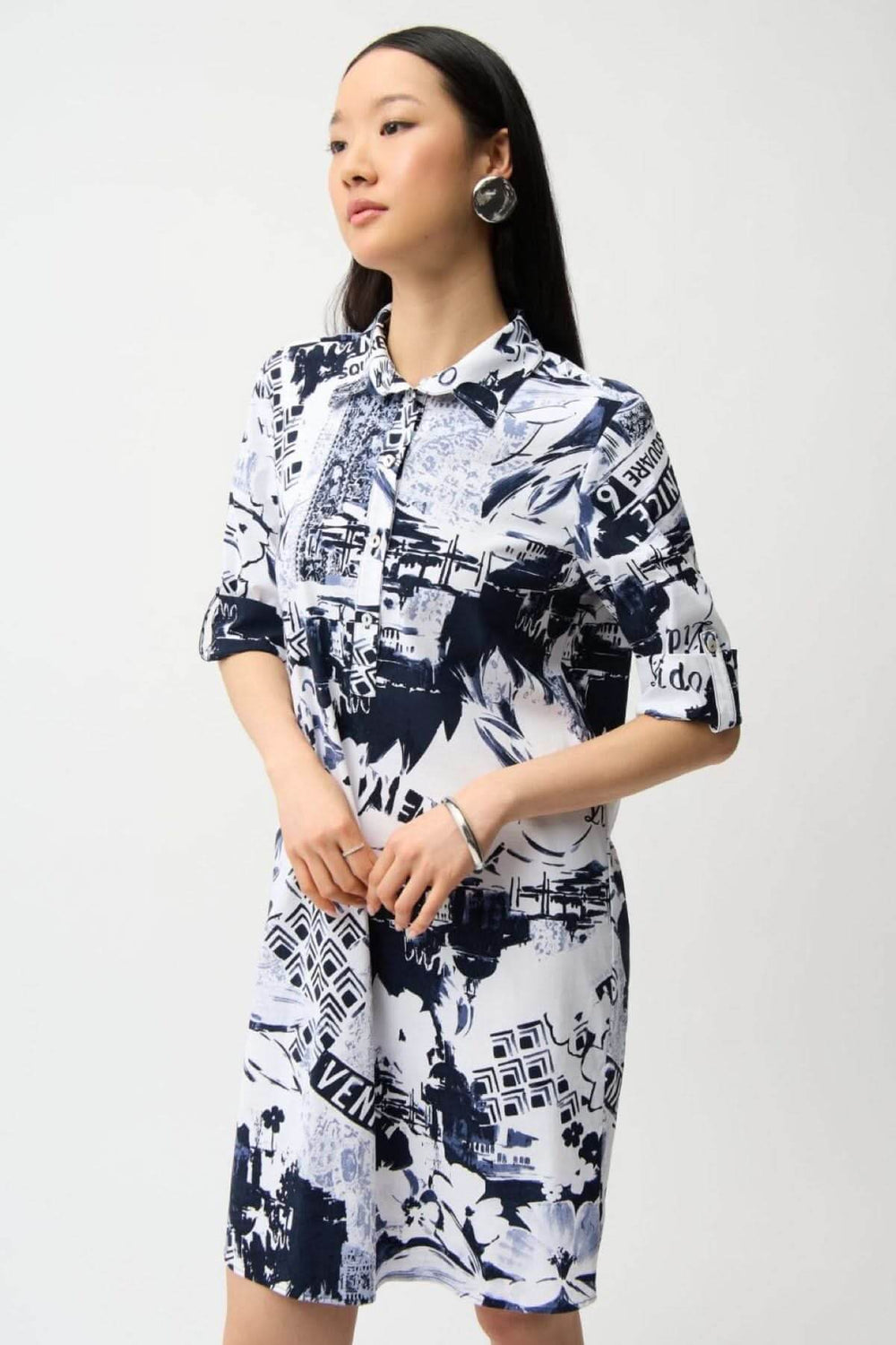 Robe chemise imprimée avec imprimé graphique urbain, col chemise, patte de boutonnage, coupe droite et fluide, portée par un mannequin.