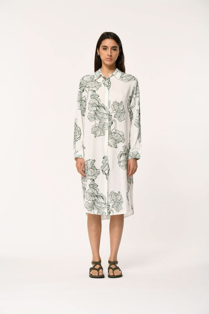 Femme portant une robe chemise imprimée longueur midi JASAR avec un design élégant et moderne, coupe fluide et col chemise classique.