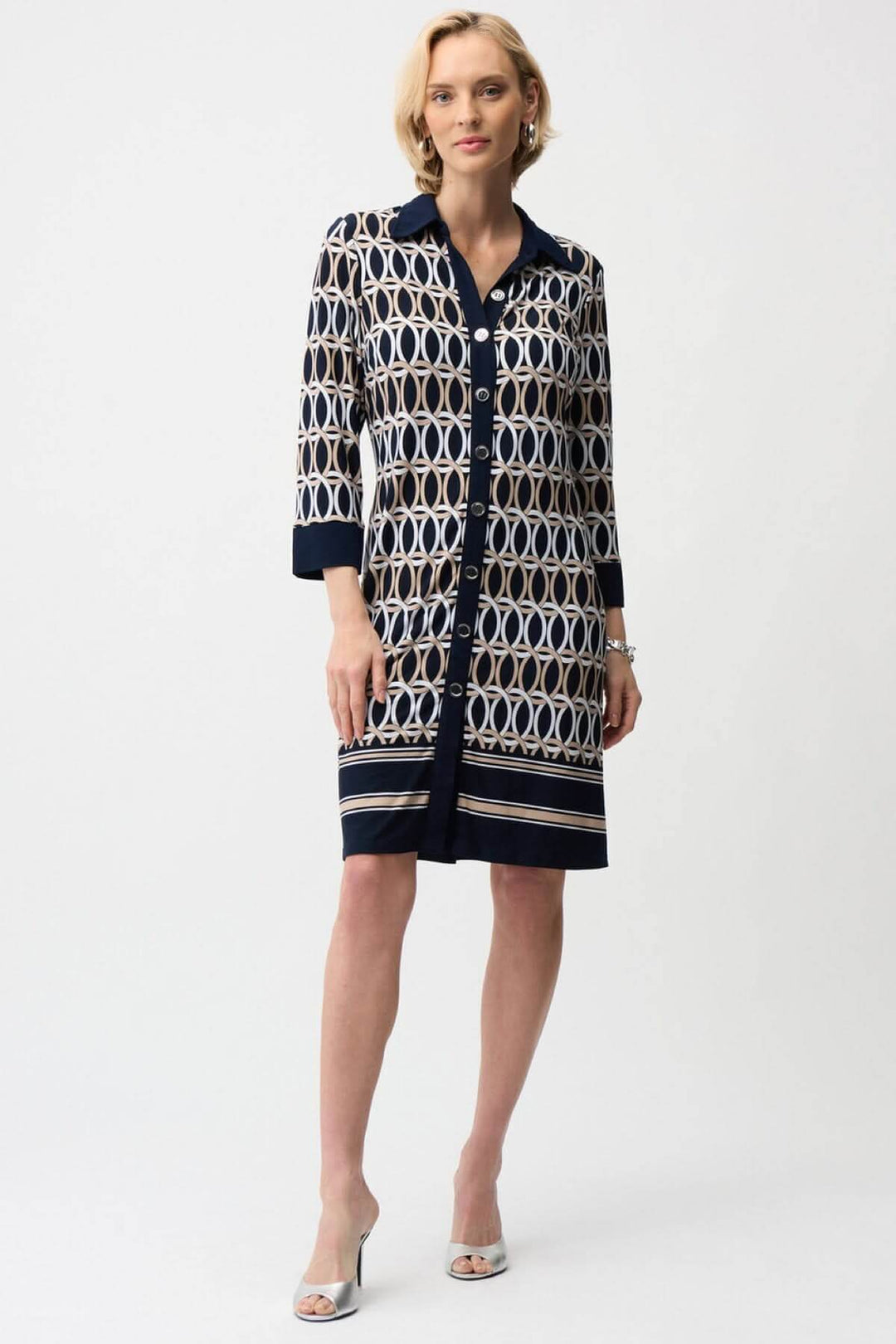 Femme portant une robe chemisier imprimée graphique avec motifs géométriques et fermeture boutonnée, élégante et polyvalente pour toutes occasions.