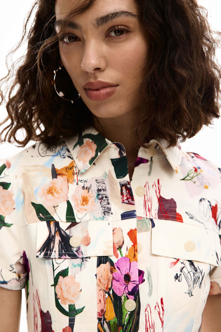 Femme portant une robe courte collage avec imprimé artistique et col chemise.