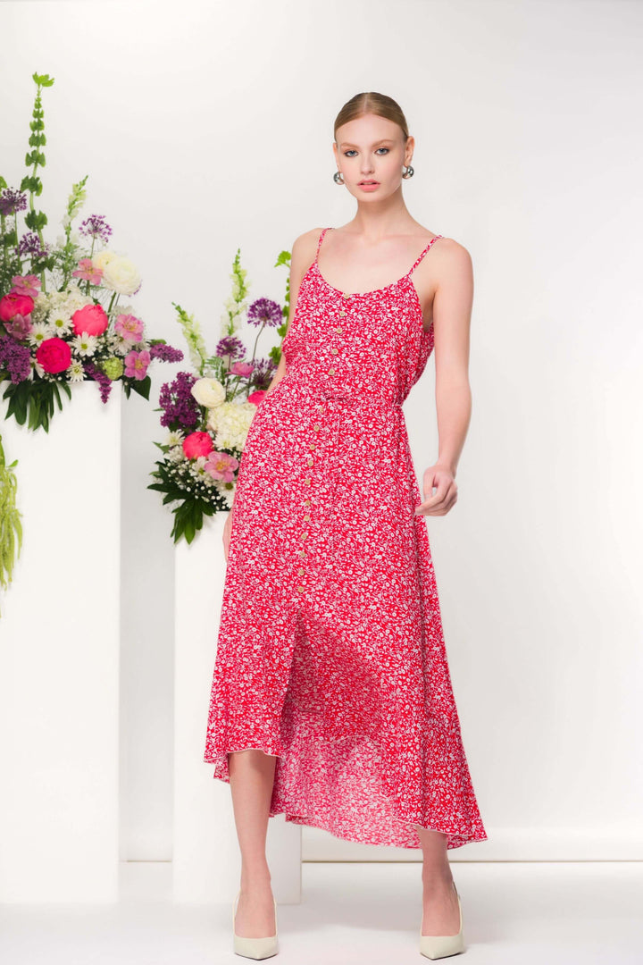 Robe fleurie midi fluide avec imprimé délicat, bretelles fines et coupe évasée, devant un fond floral, idéale pour l&