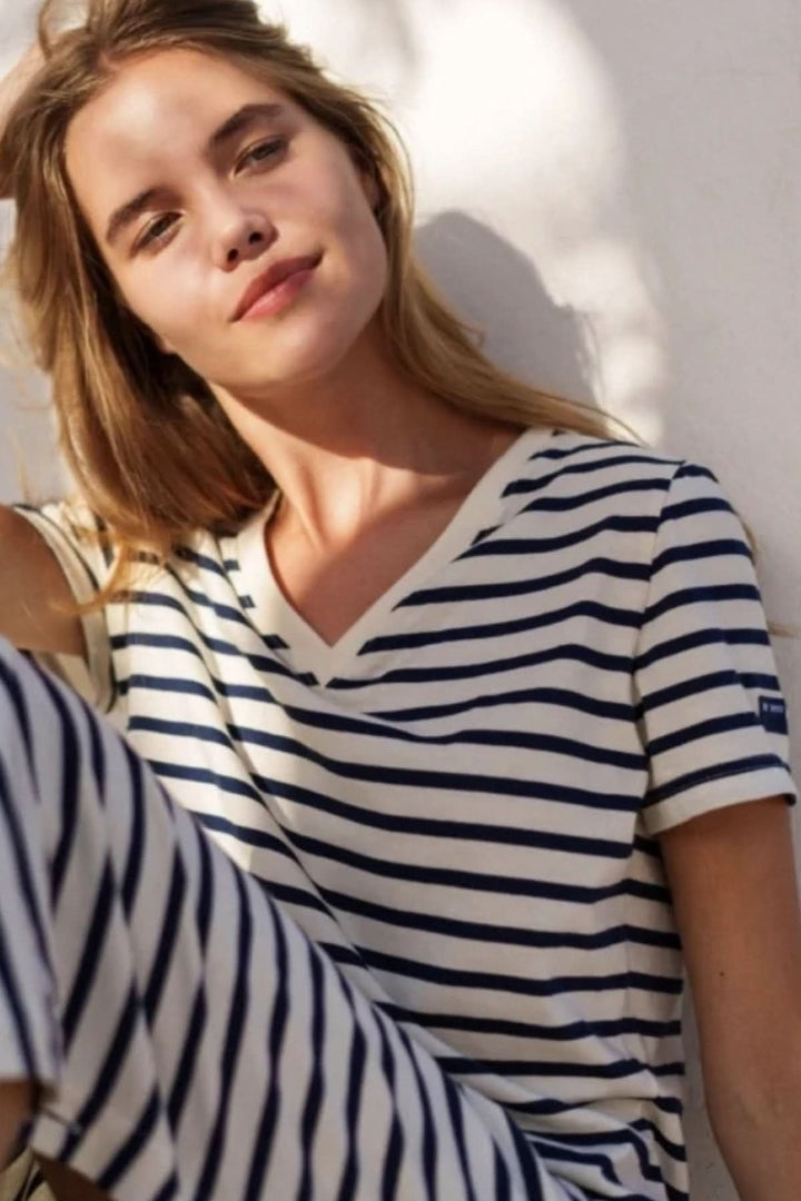 Femme portant une robe longue rayée Eze avec encolure en V, idéale pour un look chic et décontracté en été.