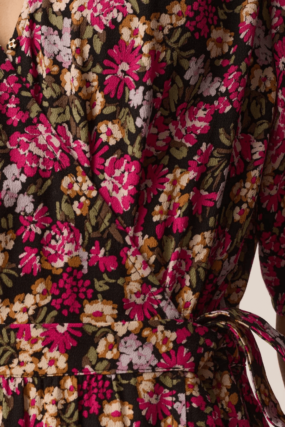 Gros plan sur motif floral de la robe midi Elaly portefeuille à manches fluides avec lien à nouer et tissu fluide.