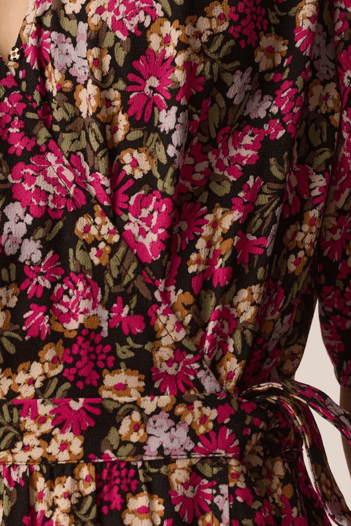 Gros plan sur motif floral de la robe midi Elaly portefeuille à manches fluides avec lien à nouer et tissu fluide.