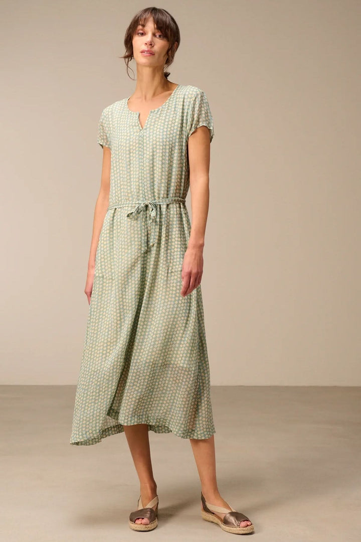 Femme portant une robe midi fluide avec ceinture à nouer en tissu léger, manches courtes et encolure en V. Élégance casual et confort.