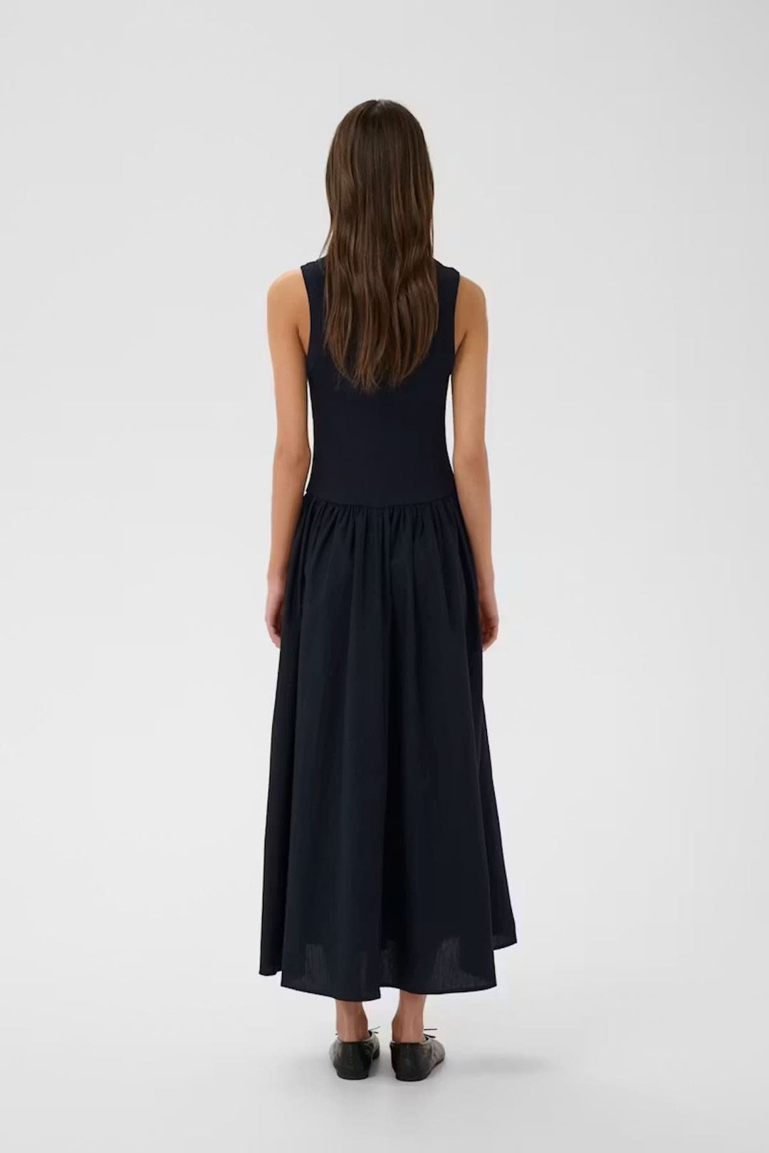 Vue arrière de la robe midi sans manches Dagnama avec jupe ample et haut ajusté, portée par un mannequin féminin sur fond neutre.