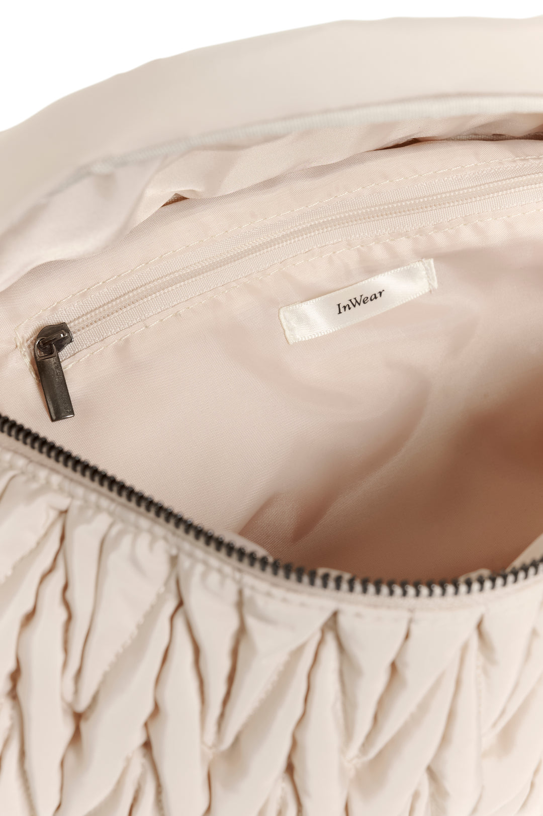 Intérieur du Sac bandoulière matelassé Samy Bumbag avec texture froncée et compartiment spacieux.
