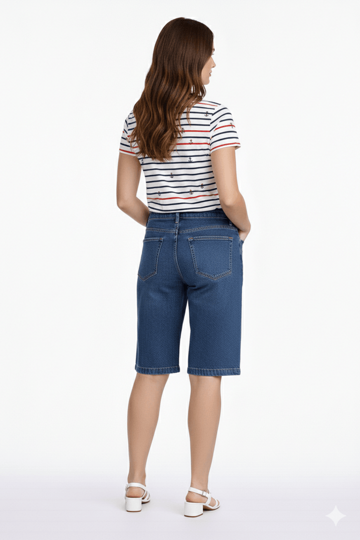 Femme portant un short bermuda ample en denim, longueur au genou, coupe décontractée et moderne, idéal pour un style estival polyvalent.
