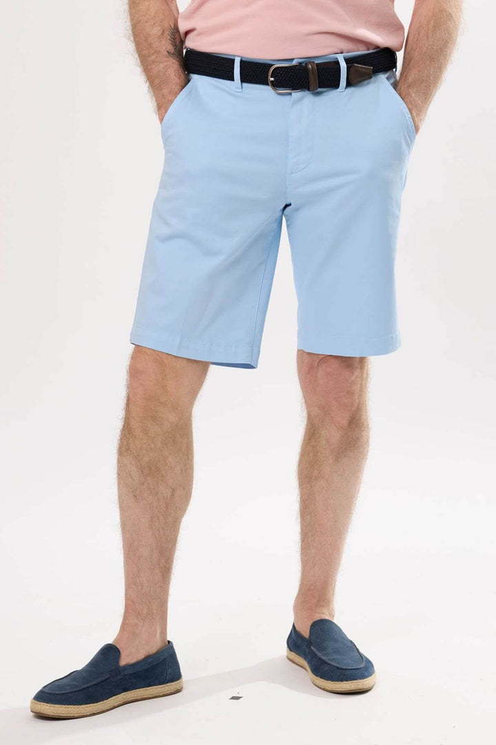 Short classique en coton léger de couleur bleu clair, porté avec un t-shirt rose et chaussures bleues.