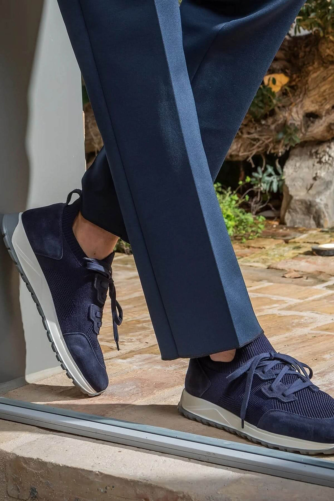 Sneaker homme cuir et tissu extensible, style moderne, semelle ultralégère, tenue chic avec pantalon bleu.