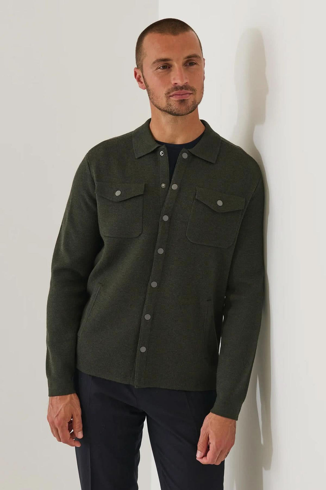Homme portant une surchemise en laine mérinos extra-fine à boutons-pression, couleur sombre élégante et style moderne décontracté.