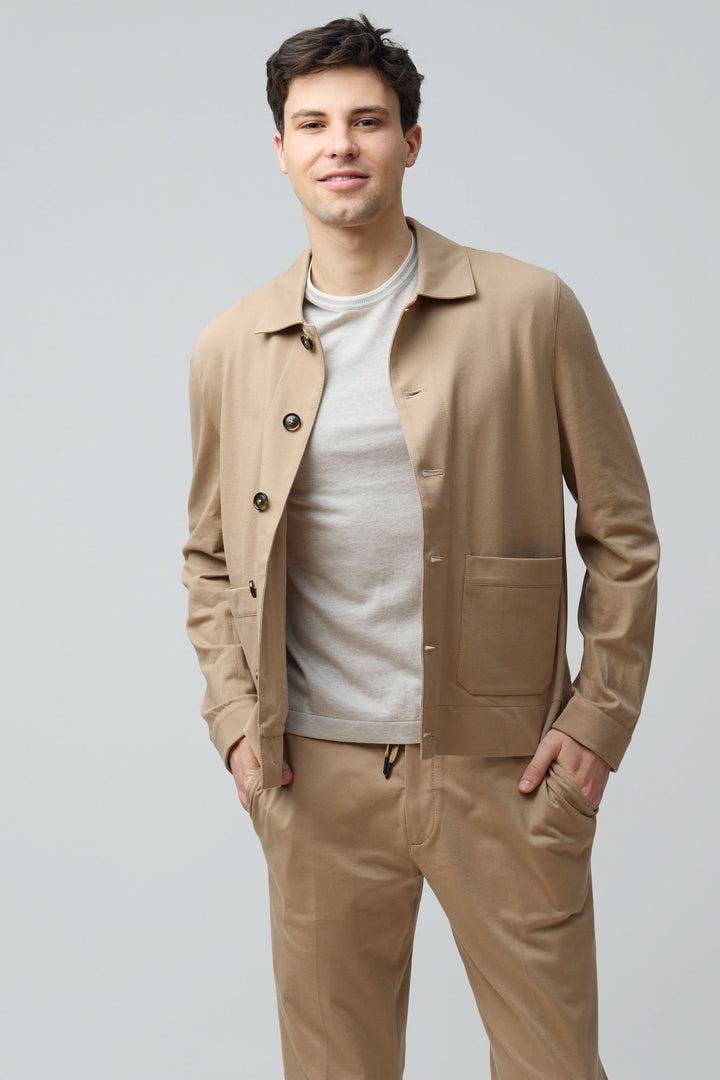 Homme portant une surchemise stretch beige avec style épuré, coupe moderne et fermeture boutonnée.