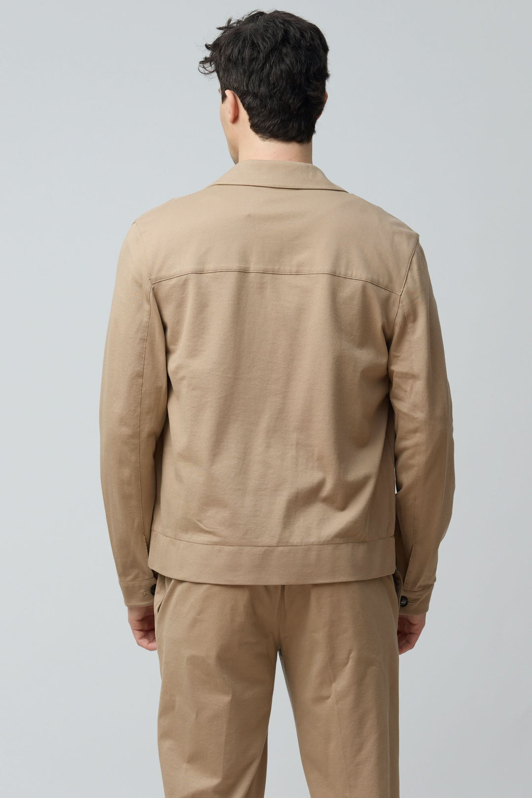 Homme portant une Surchemise stretch beige vue de dos, avec col structuré et fermeture boutonnée.