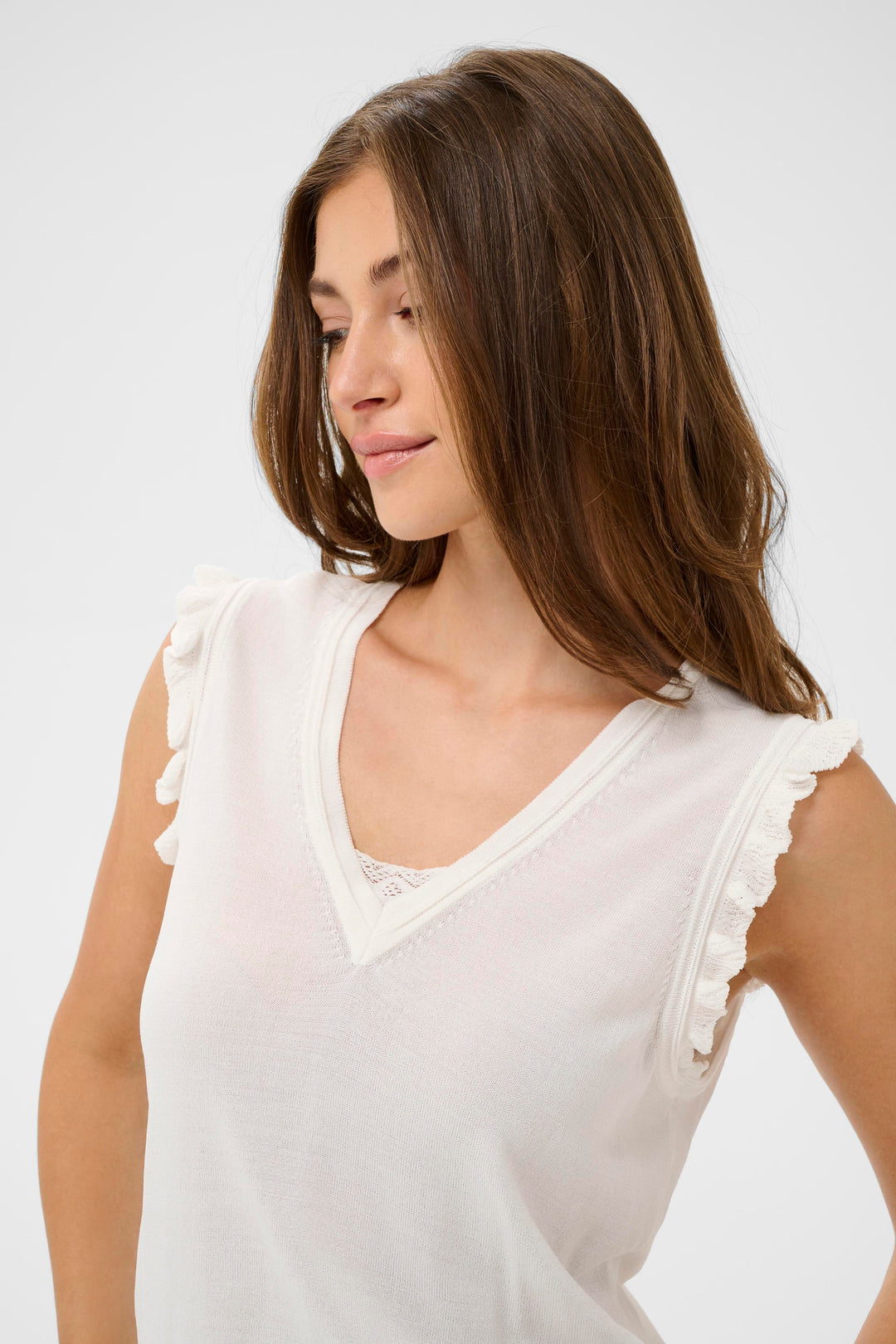 Femme portant un T-shirt Desten sans manches avec encolure en V et détails volantés, style élégant et féminin.