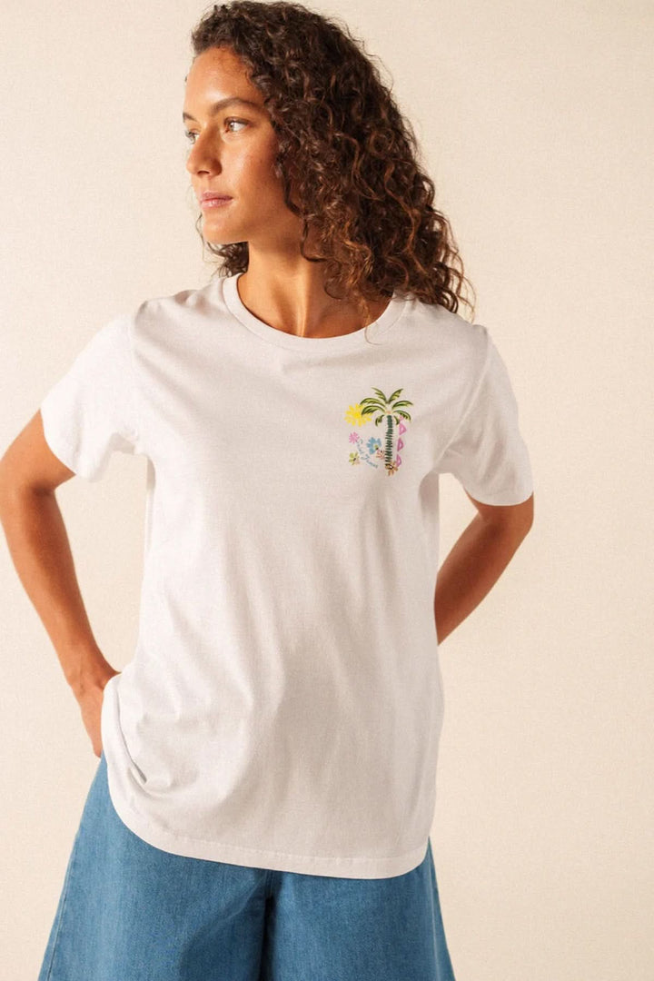 Femme portant un T-shirt Léonore blanc avec motif graphique discret, manches courtes et encolure arrondie, confortable et léger.