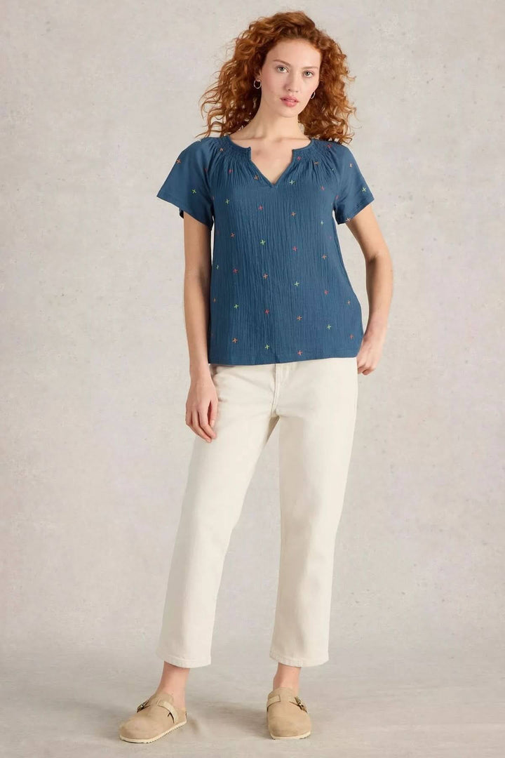 T-shirt Luella léger à manches courtes avec broderies colorées, porté avec pantalon clair.