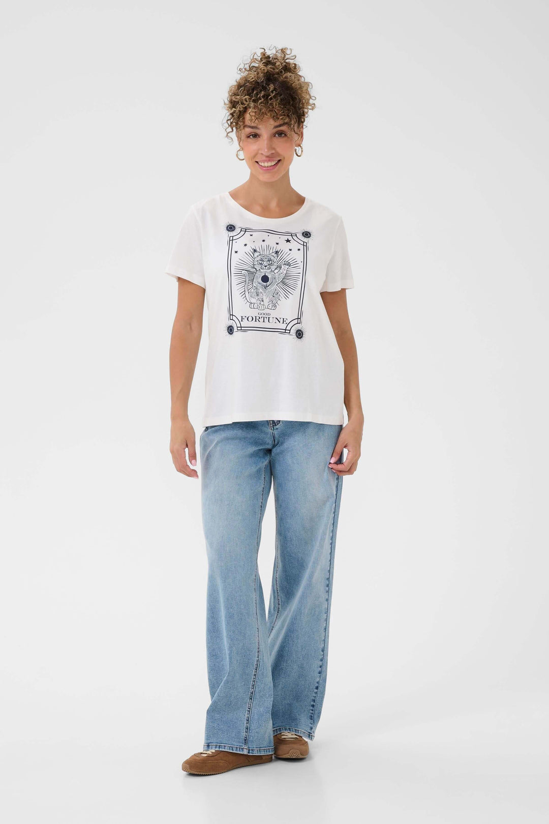 Femme portant un T-shirt Nikita avec imprimé graphique tendance, coupe droite et manches courtes, style décontracté et confortable.