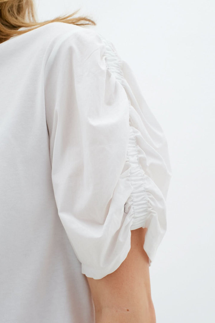 T-shirt Payana blanc avec manches froncées et col rond, en coton doux et extensible.