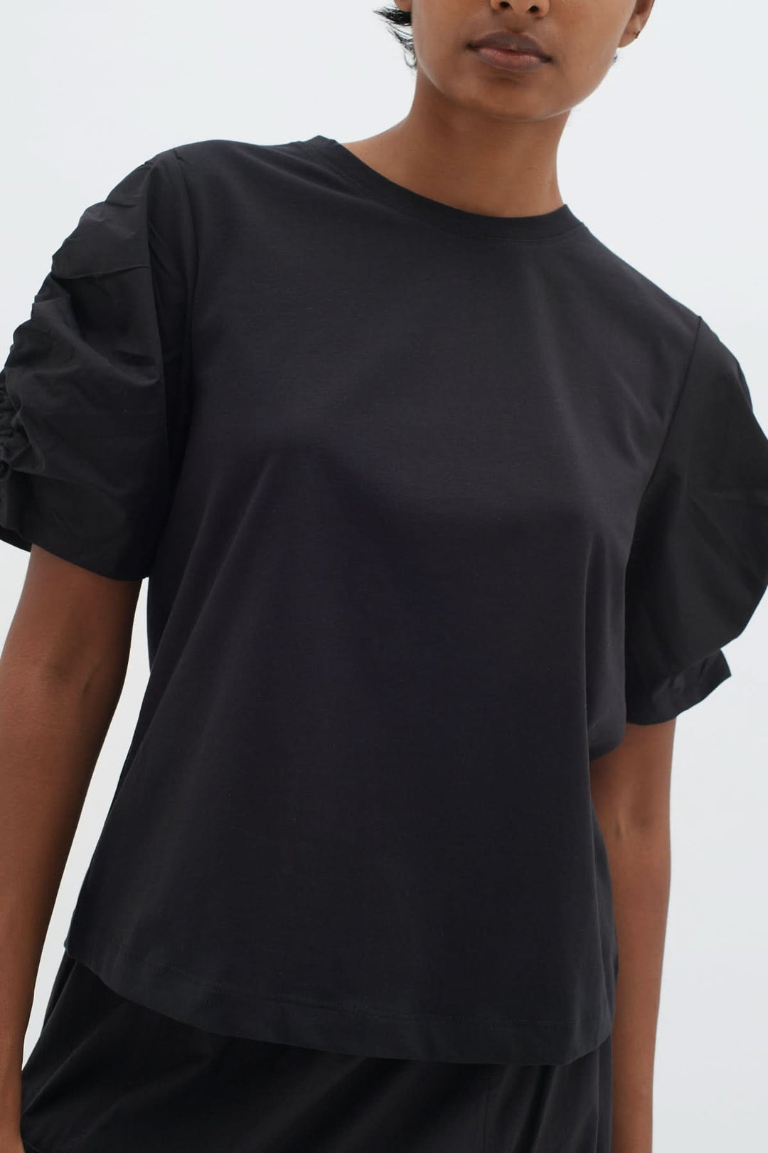 T-shirt Payana noir à manches froncées, en coton doux, style moderne.