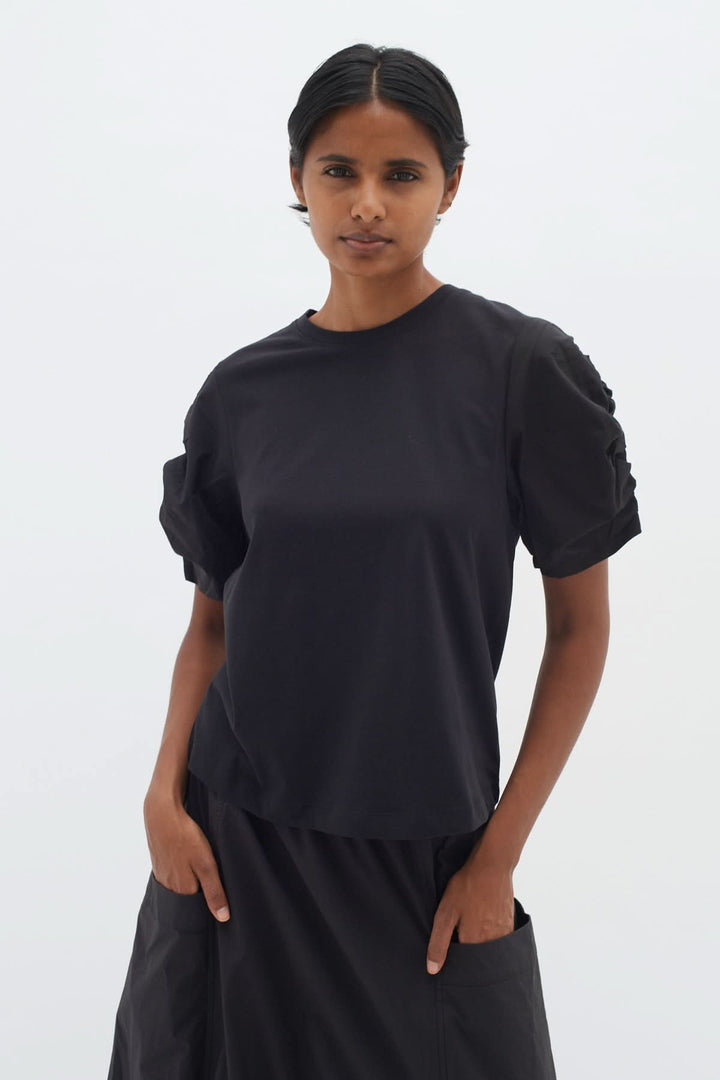 T-shirt Payana noir avec manches froncées, coupe moderne en coton, style classique revisité.