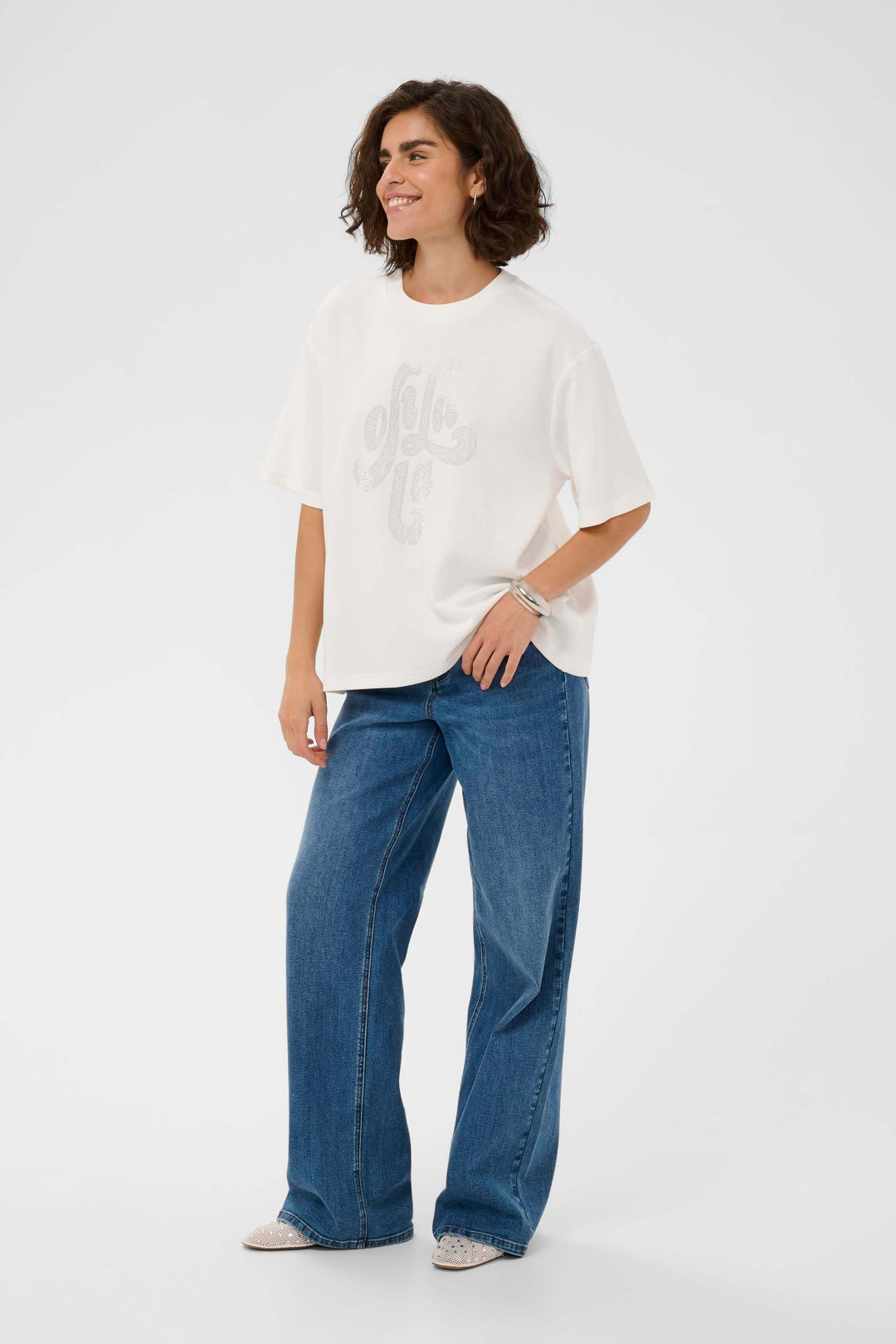 T-shirt Rosie à coupe ample avec motif décoratif, mannequin portant un look décontracté avec jean large, manches courtes et encolure ronde.