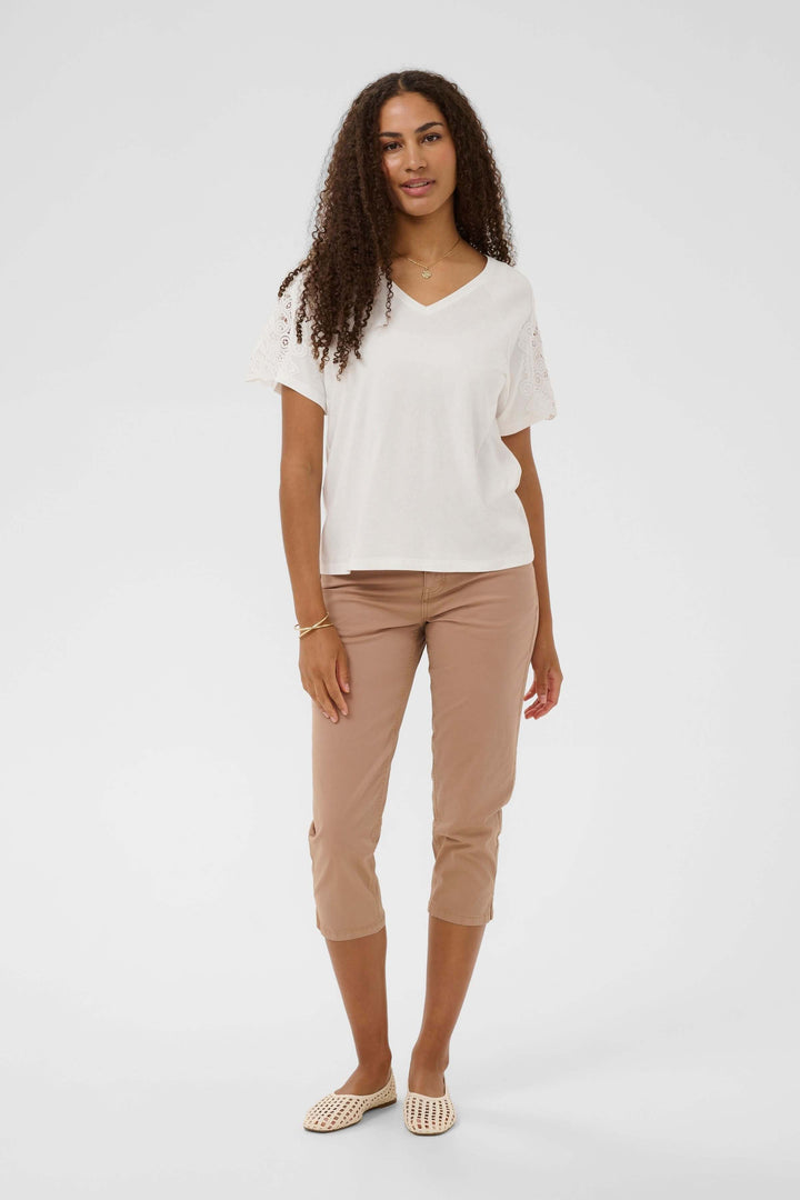 T-shirt Suny à manches courtes avec dentelle encolure en V, femme debout, vêtement confortable et élégant.