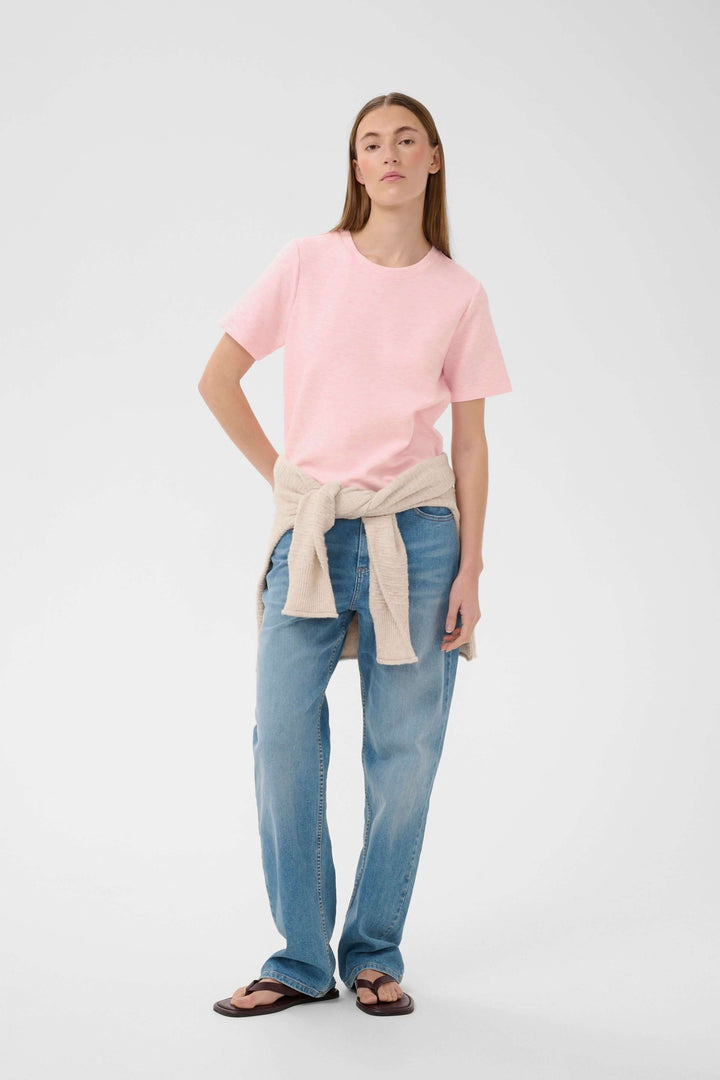 Femme portant le T-shirt Vincent rose avec une coupe droite et allure minimaliste, encolure ronde, manches courtes et finitions soignées.