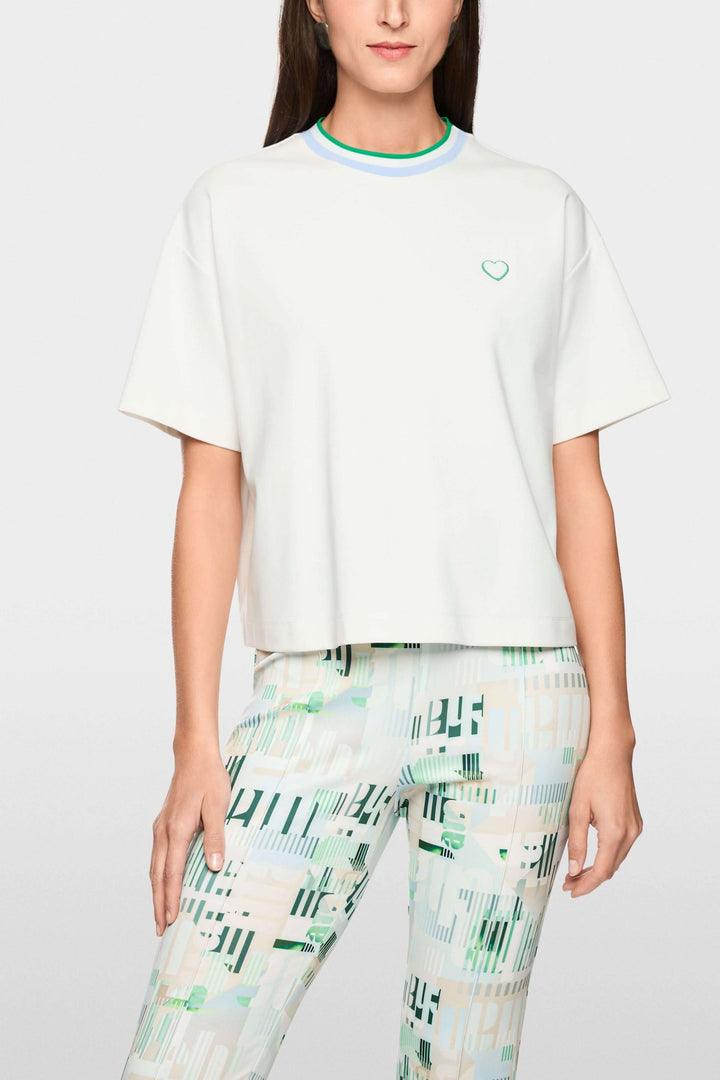 T-shirt avec détails en forme de cœur et à rayures, coupe ample et col contrastant, porté sur un mannequin.