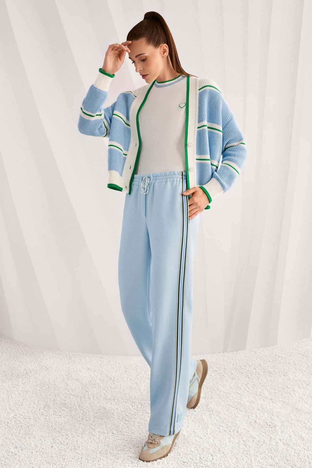 T-shirt avec détails en forme de cœur et à rayures porté avec un pantalon décontracté, décris moi le produit en français.