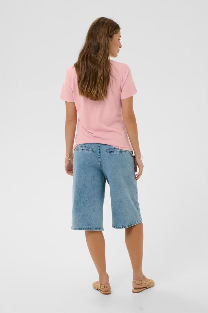 Femme portant un T-shirt col en V rose, vue de dos, avec un jean. Style décontracté et confortable. Décris moi le produit en français.