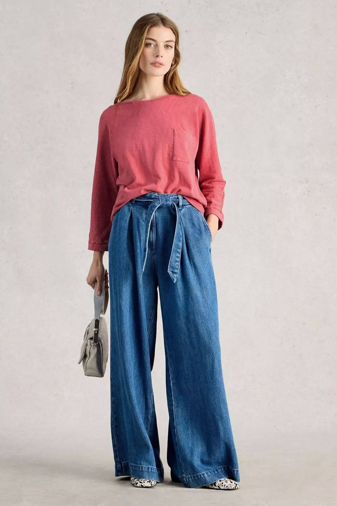 T-shirt à col rond demi-dos rouge avec manches trois-quarts, poche plaquée, porté avec un jean large et sac à main gris.