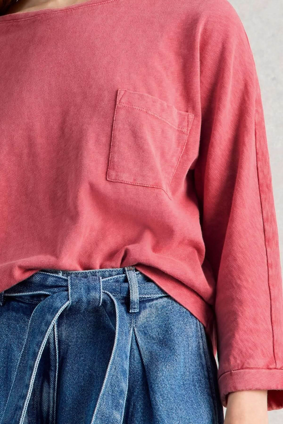 T-shirt à col rond demi-dos en tissu doux avec manches trois-quarts et poche poitrine, offrant une coupe droite et confort naturel.